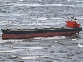 The aerial view photo shows the Panama-flagged bulk carrier Glory Amsterdam which ran aground off the shore of the German North Sea island of Langeoog, Monday, Oct. 30, 2017. German rescue experts hope to free the cargo ship that ran aground on a North Sea sandbank in a weekend storm. High winds lashed Central Europe on Sunday, knocking down trees, causing travel chaos and leaving five people dead. (Mohssen Assanimoghaddam/dpa via AP)