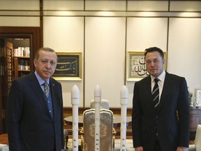 Turkey's President Recep Tayyip Erdogan, left, poses for photographs with Elon Musk, right, Tesla and SpaceX CEO, prior to their meeting in Ankara, Turkey, Wednesday, Nov. 8, 2017. Erdogan's office did not immediately provide details on the meeting, however it comes days after a consortium of five Turkish businesses, including mobile phone operator Turkcell, launched a joint venture to design and produce a Turkish-made car, a joint venture was launched under Erdogan's urging. (Pool Photo via AP)