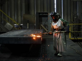 An employee performs a quality check on a steel slab at the Stelco Holdings Inc. plant in Nanticoke, Ontario.