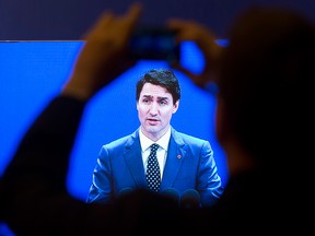 Prime Minister Justin Trudeau is broadcast on a large screen as he delivers a speech at the Fortune Global Forum in Guangzhou, China, on Wednesday, Dec. 6, 2017.