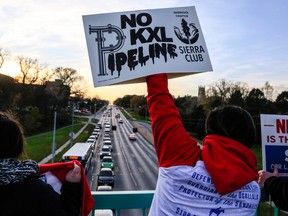 Opponents of the Keystone XL pipeline demonstrate on the Dodge Street pedestrian bridge during rush hour in Omaha, Neb., on Nov. 1, 2017.