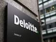 A Deloitte logo is pictured on a sign outside the company's offices in London.