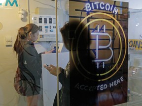 Two people use a bitcoin ATM in Hong Kong.