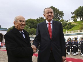 Turkey's President Recep Tayyip Erdogan, left, and Tunisian President Beji Caid Essebsi shake hands as they inspect a military honour guard in Tunis, Tunisia, Wednesday, Dec. 27, 2017. Erdogan is in Tunisia for a State visit.