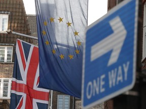 A Union Flag, an EU Flag and a 'One Way' street sign are seen in London on Friday, after a significant breakthrough was made in the divorce negotiations between Britain and the EU over Brexit.