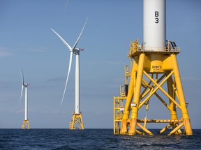 FILE - In this Monday, Aug. 15, 2016, file photo three wind turbines from the Deepwater Wind project stand in the Atlantic Ocean off Block Island, R.I. Fishermen are turning a wary eye toward an emerging upstart: the offshore wind industry. New Bedford, Mass., fishermen say they're concerned about navigating a forest of turbines to get to their historical fishing grounds and getting trawling gear caught up on transmission cables on the seafloor.