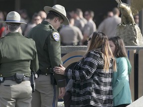 Rosanna Camilleri, right, the wife of late California Highway Patrol Officer Andrew Camilleri Sr, talks with CHP officer Jonathan Velazquez following a bell ringing ceremony held at the highway patrol academy Wednesday, Dec. 27, 2017, in West Sacramento, Calif. Camilleri Sr, was sitting into the passenger seat of the patrol vehicle operated by Velazquez, that was parked on the shoulder of Interstate 880 Christmas Eve night when their vehicle was struck by a vehicle that drifted off the highway. Camilleri Sr. was killed and Velazquez, who suffered miner injuries, was treated and released from a nearby medical center. The driver of the other vehicle, who was believed to be under influence of marijuana and alcohol at the time of the accident, remains in the hospital with serious injuries.