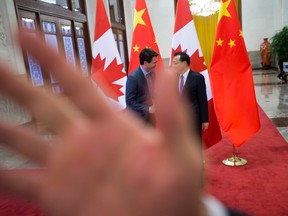 A security guard attempts to block a photographer from taking a picture Prime Minister Justin Trudeau being greeted by Chinese Premier Li Keqiang at the Great Hall of the People in Beijing on Monday. The incident happened following a difference of opinion between Canadian and Chinese government staff regarding the number of foreign journalist and prime ministerial staff allowed to witness the photo opportunity.