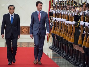 Canada's Prime Minister Justin Trudeau and China's Premier Li Keqiang, left, walk during a review of Chinese paramilitary guards during a welcome ceremony at the Great Hall of the People in Beijing Monday.