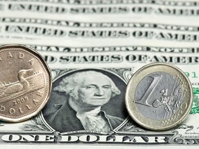 The Canadian dollar was trading at 77.62 cents US, down from an average price of 77.80 cents US on Wednesday. A Canadian dollar, left, and a Euro are seen next to a series of U.S. dollars in this January 26, 2011 photo in Montreal.