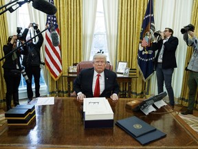 President Donald Trump speaks to reporters after signing the tax bill and continuing resolution to fund the government, in the Oval Office of the White House, Friday, Dec. 22, 2017, in Washington.