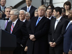 Senate Majority leader Mitch McConnell of Ky., speaks as President Donald Trump, House Speaker Paul Ryan of Wis., and Sen. Tim Scott, R-S.C., right, listen during a bill passage event on the South Lawn of the White House in Washington, Wednesday, Dec. 20, 2017, to acknowledge the final passage of tax cut legislation by Congress.