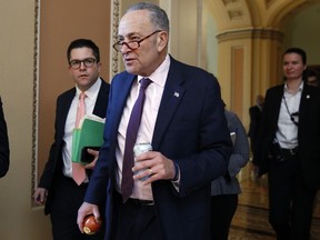 Senate Minority Leader Sen. Chuck Schumer of N.Y., center, walks through the Capitol, Friday, Dec. 1, 2017, on Capitol Hill in Washington. Republican leaders believe they have the votes to approve a GOP overhaul of the tax code.