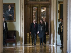 Senate Majority Leader Mitch McConnell, R-Ky., accompanied at right by Secretary for the Majority Laura Dove, walks to his office from the chamber as Republicans in the House and Senate plan to pass the sweeping $1.5 trillion GOP tax bill on party-line votes, at the Capitol in Washington, Monday, Dec. 18, 2017.
