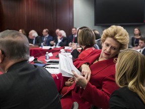 Sen. Debbie Stabenow, D-Mich., a member of the Senate Finance Committee, confers with an aide as tax bill conferees gather to work on the sweeping GOP plan, on Capitol Hill in Washington, Wednesday, Dec. 13, 2017.