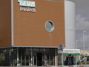 A man walks out of Teva Pharmaceutical facility building in Neot Hovav, Israel, Thursday, Dec. 14, 2017. Teva Pharmaceutical Industries Ltd., the world's largest generic drugmaker, says it is laying off 14,000 workers as part of a global restructuring. The company said Thursday that the layoffs represent over 25 percent of its global work force.