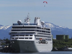 FILE - This June 26, 2014, file photo, shows a cruise ship docked in Juneau, Alaska, while a paraglider soars above. The tax bill approved Saturday, Dec. 2, 2017, by the U.S. Senate will open part of the Arctic National Wildlife Refuge to oil and gas drilling. The measure also struck down a proposed cruise ship tax that Republican Sen. Lisa Murkowski said would have disproportionately affected her state.