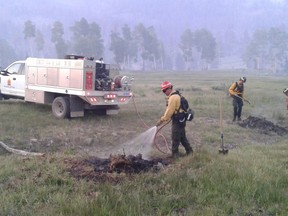 This July 2017 photo provided by Chubb shows the Wildfire Defense Systems, Inc. firefighters mopping up spot fires on a clients property during a wildfire in Panguitch, Utah. Among the army of firefighters protecting entire neighborhoods at the front lines of Southern California's monstrous wildfire are teams hired by insurance companies that offer personalized prevention and protection services for individual homeowners. (Chubb via AP)