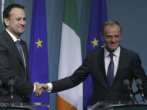 President of the European Council, Donald Tusk, right, shakes hands with Irish Prime Minister Leo Varadkar at a press conference at Government Buildings in Dublin to discuss preparations for the December European Council, Friday Dec. 1, 2017. The European Union warned Britain Friday that it must reveal by next week how it plans to keep an open Irish border after Brexit or the bloc will refuse to negotiate a new trade deal with the U.K.