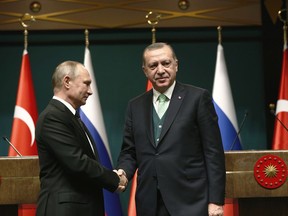 FILE - In this Monday, Dec. 11, 2017 file photo, Turkey's President Recep Tayyip Erdogan, right, shakes hands with Russia's President Vladimir Putin, left, following their joint news statement after their meeting at the Presidential Palace in Ankara, Turkey. NATO-member Turkey has finalized a deal with Moscow to purchase a Russian-made anti-missile system. Under the deal announced by Turkish defense officials on Friday, Dec. 29, 2017. Turkey would buy at least one S-400 surface-to-air missile battery with the option of procuring a second battery. The deal would make Turkey the first NATO member to own Russia's most advanced air defense system and, comes amid Ankara's deteriorating relations with the United States and other western countries.