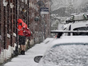 A postman delivers mail while seeming to deny the cold weather by wearing a pair of shorts, in Stalybridge, Manchester, in England, Saturday Dec. 9, 2017. A cold front has bought snow and ice to many parts of England, with predictable disruption to the roads and some forecasters warning that communities could be cut off as temperatures plummet.