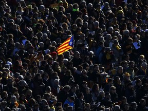Demonstrators attend a concert holding a 'Estelada', the pro-independence Catalan flag, in support of the politicians and and civil leaders imprisoned at the Plaza Espanya square in Barcelona, Sunday, Dec. 3, 2017. A Spanish Supreme Court judge is set to decide on Monday if two Catalan pro-independence activists and eight former members of the separatist regional cabinet ousted over a month ago should be released from custody after hearing their appeal.