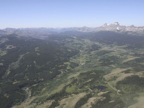This June 16, 2015 aerial photo, shows the Badger-Two Medicine  area near the Blackfeet Indian Reservation and Glacier National Park, rear, in Montana. Even as it clashes with American Indians over reductions to national monuments in the Southwest, the Trump administration is engaging with a Montana tribe over the creation of a new monument next to its reservation. The mountainous area was part of the Blackfeet reservation until the 1890s.