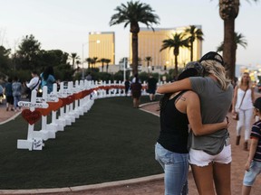 FILE - In this Oct. 5, 2017, file photo, a memorial displaying 58 crosses by Greg Zanis stands at the Welcome To Las Vegas Sign in Las Vegas. Each cross has the name of a victim killed during the mass shooting at the Route 91 Harvest country music festival. Dozens of people were killed and hundreds were injured. Tens of thousands of revelers will ring in the New Year in Las Vegas under the close eye of law enforcement just three months after the deadliest mass shooting in modern U.S. history.
