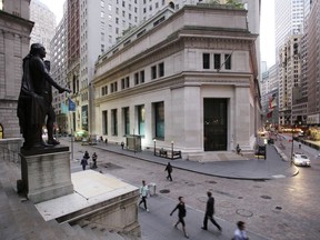 FILE - In this Oct. 8, 2014, file photo, people walk to work on Wall Street beneath a statue of George Washington, in New York. U.S. stocks edged mostly higher in early trading Tuesday, Dec. 12, 2017, as investors sized up the latest company earnings and deal news. Gains by banks and health care companies outweighed losses among technology companies. Energy stocks also declined as the price of crude oil headed lower.