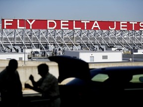 FILE - In this Thursday, Oct. 13, 2016, file photo, a Delta Air Lines sign overlooks the unloading area at Hartsfield-Jackson Atlanta International Airport, in Atlanta. On Thursday, Dec. 14, 2017, Delta announced it will order 100 Airbus A321neo jets with a sticker price of $12.7 billion and take an option to buy another 100 jets, a deal that Chicago-based Boeing had hoped to land.