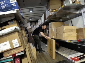 In this Tuesday, May 9, 2017, photo, a UPS employee loads packages onto a truck at a company facility in New York. With Christmas on a Monday, most retailers have one less day to get packages delivered on time. UPS said earlier in December that some package deliveries were being delayed because of a surge of orders from online shoppers after Thanksgiving.
