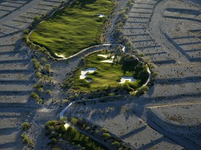In this June 16, 2016, photo, shrubs grow on empty housing pads around a hole at the Coyote Springs golf course in the Coyote Springs development about 50 miles northeast of Las Vegas. Before the housing bubble burst, developers planned to create a new community out of the desert with thousands of homes, several golf courses and other amenities. But the housing bubble burst, with only the golf course completed before the project stalled.