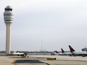 FILE- This May 9, 2016, file photo, shows an air traffic control tower at their gates at Hartsfield–Jackson Atlanta International Airport in Atlanta. Authorities say a power outage at the Hartsfield-Jackson Atlanta International Airport has disrupted ingoing and outgoing flights. Airport spokesman Reese McCraine says the outage occurred early Sunday, Dec. 17, 2017. He says all airport operations are being affected and that outgoing flights were halted.