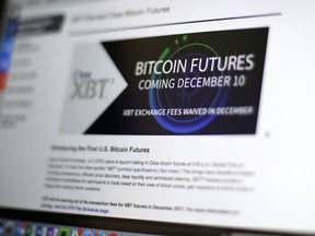 FILE - This Dec. 8, 2017, file photo shows the Chicago Board Options Exchange website announcing that bitcoin futures will start trading on the Cboe on Sunday evening Dec. 10. The CME Group, another security based on the price of bitcoin, the digital currency that has soared in value and volatility this year, began trading on the Chicago Mercantile Exchange on Sunday, Dec. 17.