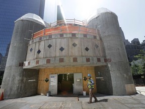 FILE- In this Aug. 10, 2017 file photo, a construction worker walks in front of the St. Nicholas National Shrine in New York. Work on the Greek Orthodox church destroyed in the Sept. 11 attacks next to the World Trade Center memorial plaza has been temporarily suspended by the construction company.  It comes amid financial difficulties and questions over how funds have been managed.