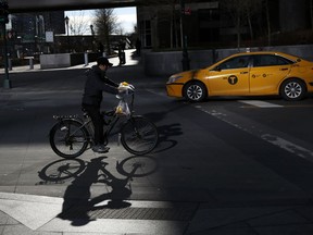 In this Thursday, Dec. 21, 2017 photo, a man making deliveries rides an electronic bike in New York. A plan to intensify a crackdown on electric bicycles is causing concern among the New York City's delivery workforce.