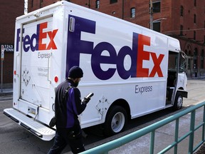 In this Friday, March 17, 2017, photo, a FedEx driver returns to his truck in downtown Pittsburgh. FedEx Corp. reports earnings Tuesday, Dec. 19, 2017.