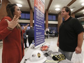 In this Thursday, Nov. 2, 2017, photo, a recruiter from a driller in the shale gas industry, left, speaks with an attendee at a job fair in Cheswick, Pa. On Friday, Dec. 8, 2017, the U.S. government issues the November jobs report.