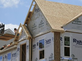 In this Thursday, June 1, 2017, photo, builders work on the roof of a home under construction at a housing plan in Jackson Township, Butler County, Pa. On Friday, Dec. 22, 2017, the Commerce Department reports on sales of new homes in November.