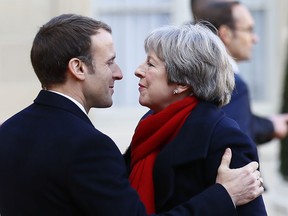 British Prime Minister Theresa May is welcomed by French President before a lunch at the Elysee Palace in Paris, Tuesday, Dec. 12, 2017. More than 50 world leaders are gathering in Paris for a summit that Macron hopes will give new momentum to the fight against global warming, despite U.S. President Donald Trump's rejection of the Paris climate accord.