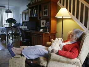 In this Friday Dec. 1, 2017, photo, 93-year-old Mary Derr sits with her robot cat she calls "Buddy" in her home she shares with her daughter Jeanne Elliott in South Kingstown, R.I.