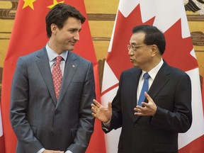 Canadian Prime Minister Justin Trudeau, left, and Chinese Premier Li Keqiang speak during a signing ceremony at the Great Hall of the People in Beijing Monday, Dec. 4, 2017.