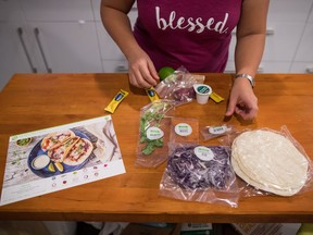Jayne Zhu lays out ingredients along side an instruction card before preparing a Hello Fresh cajun fish tacos meal kit, at her home in Vancouver, B.C., on Wednesday December 6, 2017. Home-delivered meal kits have quickly grown into a $120-million industry in Canada, according to analysts.