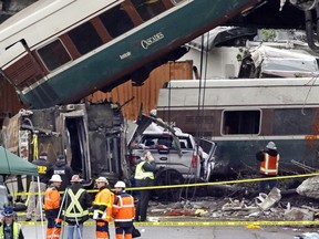 Cars from an Amtrak train that derailed above lay spilled onto Interstate 5 alongside smashed vehicles Monday, Dec. 18, 2017, in DuPont, Wash. The Amtrak train making the first-ever run along a faster new route hurtled off the overpass Monday near Tacoma and spilled some of its cars onto the highway below, killing some people, authorities said.