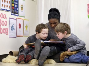 ** HOLD FOR SALLY HO STORY ** In this photo taken Feb. 12, 2016, assistant teacher D'onna Hartman, reads to Frederick Frenious, left, and Gus Saunders at the Creative Kids Learning Center, a school that focuses on pre-kindergarten for 4- and 5-year-olds, in Seattle. Hartman used the "boo boo bag" corner to settle the two down after a small altercation left one in tears. In perhaps an unexpected twist, historically conservative strongholds like Oklahoma and West Virginia are leading efforts to bring preschool to all and Alabama and Georgia are also red states that have notable programs. But some liberal leaning-cities like Seattle and New York also are running public pre-K programs.