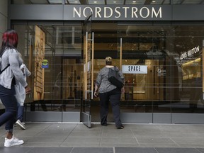 In this Wednesday, Sept. 13, 2017, photo, shoppers enter Nordstrom's flagship store in downtown Seattle. On Friday, Dec. 22, 2017, the Commerce Department issues its November report on consumer spending, which accounts for roughly 70 percent of U.S. economic activity.