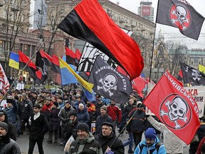 Supporters of former Georgian President Mikheil Saakashvili march carrying Ukrainian flags and flags with the words reading 'Bank riot' in protest of corruption in Ukraine in Kiev, Ukraine, Sunday, Dec. 10, 2017. From his jail cell in Ukraine's capital, opposition leader Mikheil Saakashvili is calling on supporters to rally for the impeachment of the president.