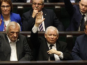 Poland's most powerful politician, ruling Law and Justice party leader Jaroslaw Kaczynski, center, attends a vote in parliament in Warsaw, Poland, on Friday, Dec. 8, 2017 in which lawmakers approved legislation that gives his party control over the Supreme Court. The opposition and the European Union leaders say the legislation threatens the rule of law.