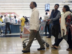 In this Wednesday, Dec. 20, 2017 photo, people leave a hypermarket at a shopping mall in Dubai, United Arab Emirates. Residents in the traditionally tax-free haven of Dubai are preparing for higher prices when the government imposes a 5 percent value-added tax on most goods like food, gasoline and water and electricity bills starting Jan. 1, 2018. Governments in oil-exporting Arab Gulf states are looking for new ways to boost revenue amid continued lower oil prices.