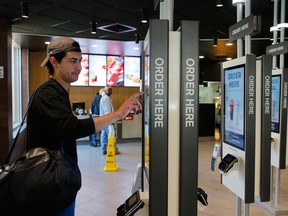 Rising minimum wages could speed up a growing trend to automate with the addition of ATMs, restaurant order screens and grocery self-checkout lines.